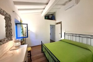A bedroom with a bed, a desk, a chair, a mirror, and a window. - Sighello Apartment (La Pila)