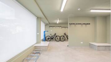 Ein sauberer, gut beleuchteter Innenraum mit einer Tafel, einer Fahrradwerkstatt und einem an der Wand befestigten Fahrradständer.
