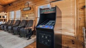 Sillas de juego en fila con una máquina recreativa Multicade en una habitación de madera con persianas.