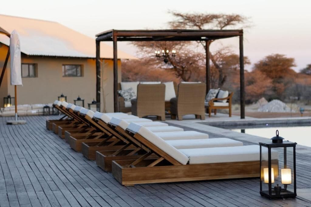 Ein Poolbereich mit Liegestühlen und einer Pergola.
