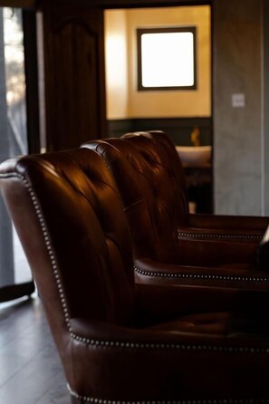 Un sillón de cuero con respaldo alto y costuras decorativas.