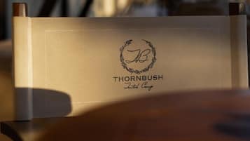 Una silla con funda de cuero y texto grabado 'THORNBUSH' y 'Tented Camp'.