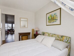 A bedroom with a large bed, a bedside table with a lamp, a mirror, and a framed picture on the wall. - Port view & beach 350m away - Apartment for 4 (Le Pouliguen)