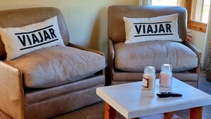 A living room with two sofas, a coffee table, and a television mounted on the wall.