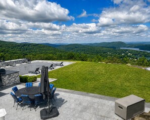 Une terrasse avec des sièges d’extérieur, une table et un espace barbecue.