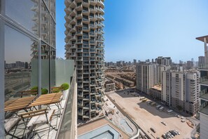 A high-rise building with a unique architectural design, featuring a series of balconies and a view of the surrounding cityscape. - StayShort - Amazing 1 Bedroom in JVC that Sleeps 4! (JVC)