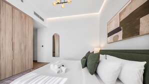 Una camera da letto moderna con un letto grande, un armadio e un quadro appeso al muro.