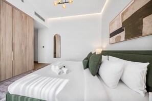 Ein modernes Schlafzimmer mit einem großen Bett, einem Kleiderschrank und einem Bild an der Wand.