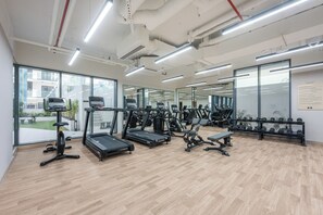 A gym with treadmills, weight machines, and a bench. - StayShort - Amazing 1 Bedroom in JVC that Sleeps 4! (JVC)