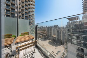 Ein hoch aufragendes Gebäude mit modernem Design, das Balkone und eine Aussicht auf die Stadt bietet.