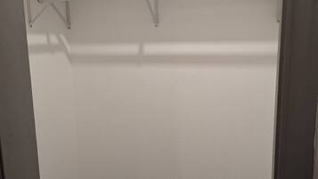 Vestidor con piso de baldosas y paredes blancas.