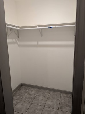 A walk-in closet with a tiled floor and white walls.