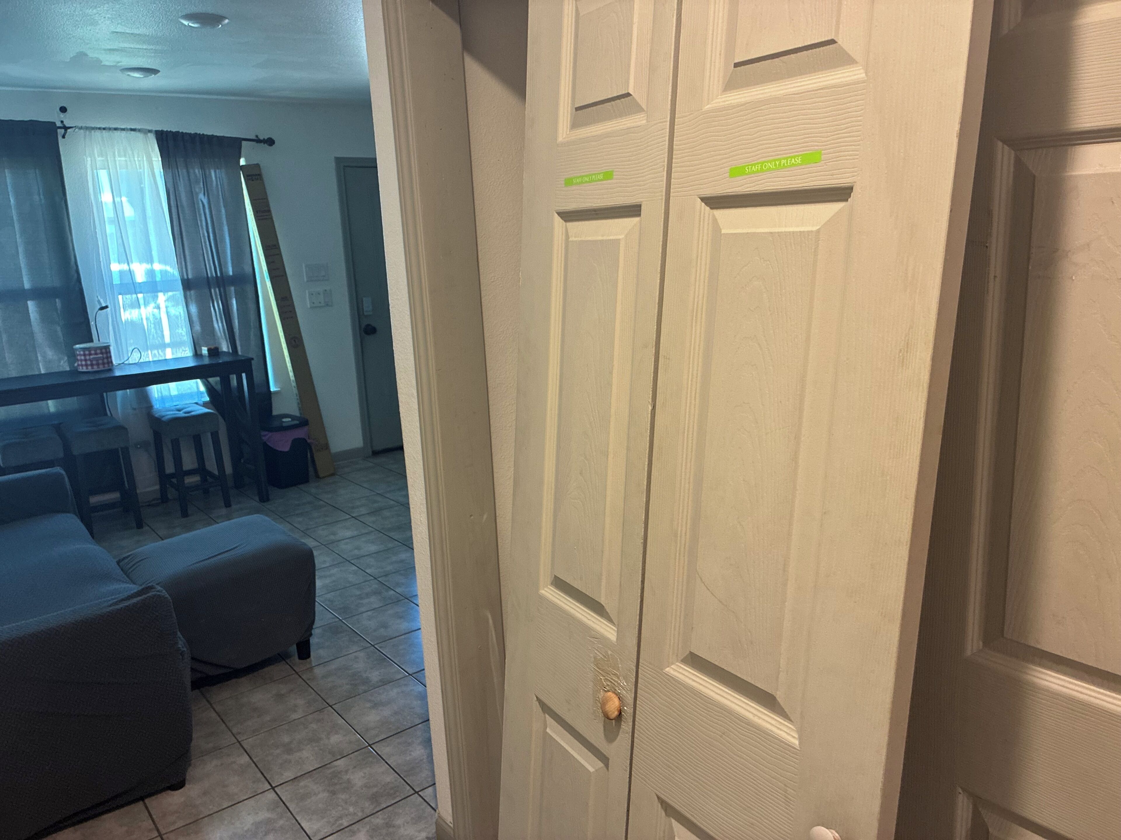 Una habitación con la puerta cerrada, una mesa de comedor con sillas y un sofá.