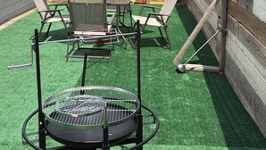 A backyard with artificial turf, a barbecue grill, and outdoor furniture. - Herrling Home (Dallas)