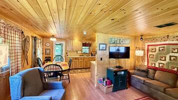 Mökki, jonka sisätiloihin kuuluu ruokailutila, keittiö ja olohuone.