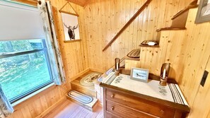 A wooden interior with a window, a mirror, a wooden dresser, and a framed picture. - Pet Friendly waterfront cabin just minutes from downtown Greenville (Greenville)