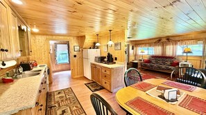 A wooden cabin interior with a kitchen, dining area, and living room. - Pet Friendly waterfront cabin just minutes from downtown Greenville (Greenville)