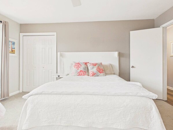 A bedroom with a bed, a headboard, and a door.