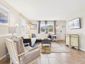 A living room with a sofa, armchair, coffee table, and a cabinet.