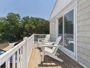 A wooden deck with white railings and two Adirondack chairs. - `The Kelly` - The Cottage Collection (Virginia Beach)