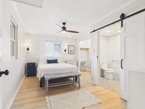 A bedroom with a bed, bedside table, and a ceiling fan. - `The Greyson` - The Cottage Collection (Virginia Beach)