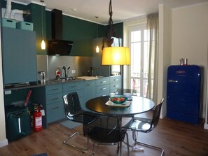 Eine kleine Küche mit Esstisch, Stühlen und einem Kühlschrank von Bosch.