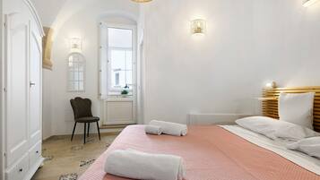 Een hotelkamer met een bed, een stoel, een bureau en een raam.