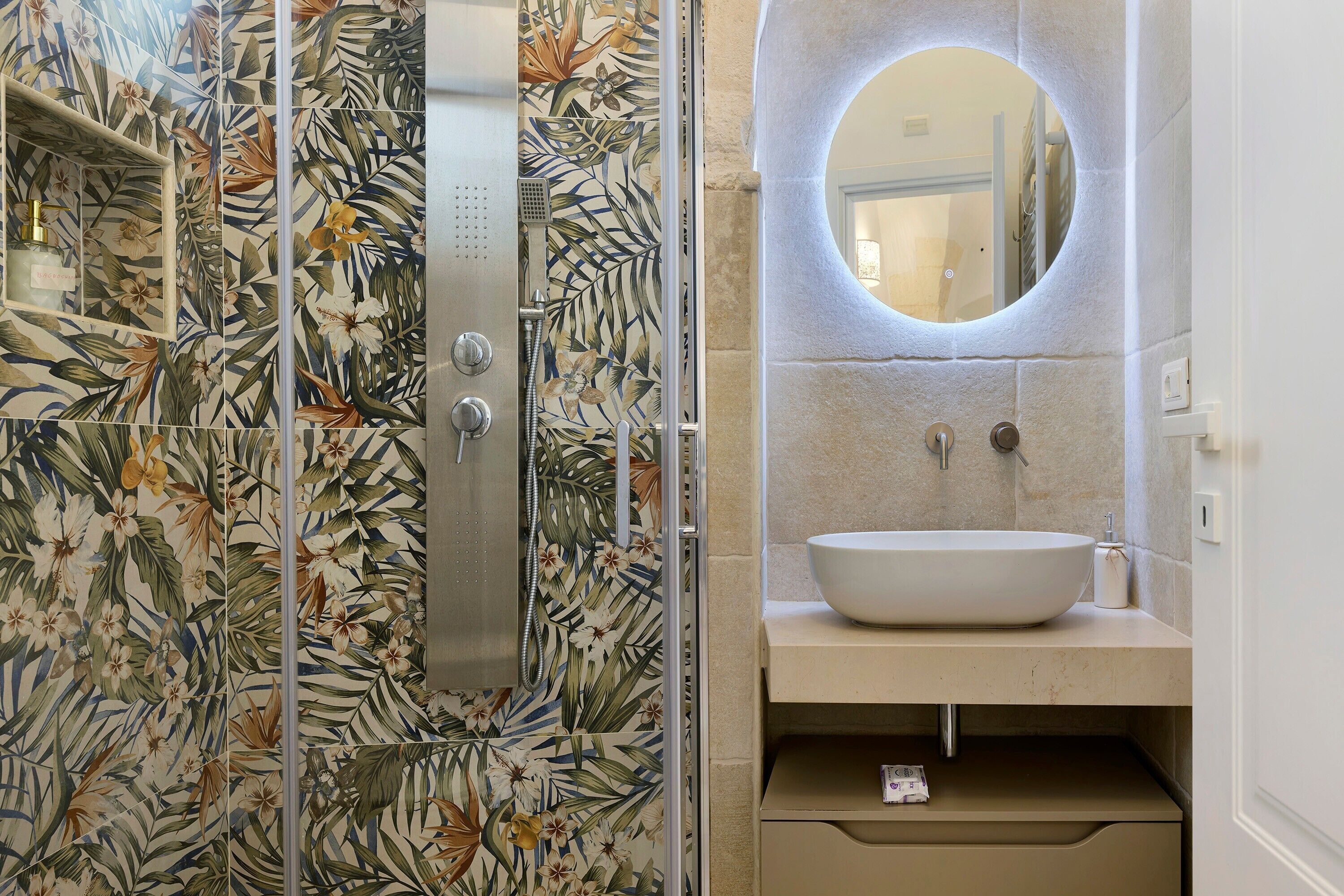 Une salle de bain avec une douche, un lavabo et un miroir.