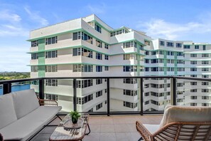 A modern multi-story building with balconies, a pool, and a view of the landscape. - Bay & Ocean View 4 BDR Spacious Condo Resort Amenities 1616 (Miami Beach)