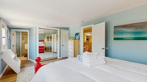 A bedroom with a large bed, a wardrobe, a chair, and a painting on the wall. - Walk to the Beach From This East End Retreat (Provincetown)