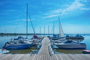 A wooden pier leading to a marina with several sailboats docked. - Comfortable holiday home with a fireplace, Bobolin (Bobolin)
