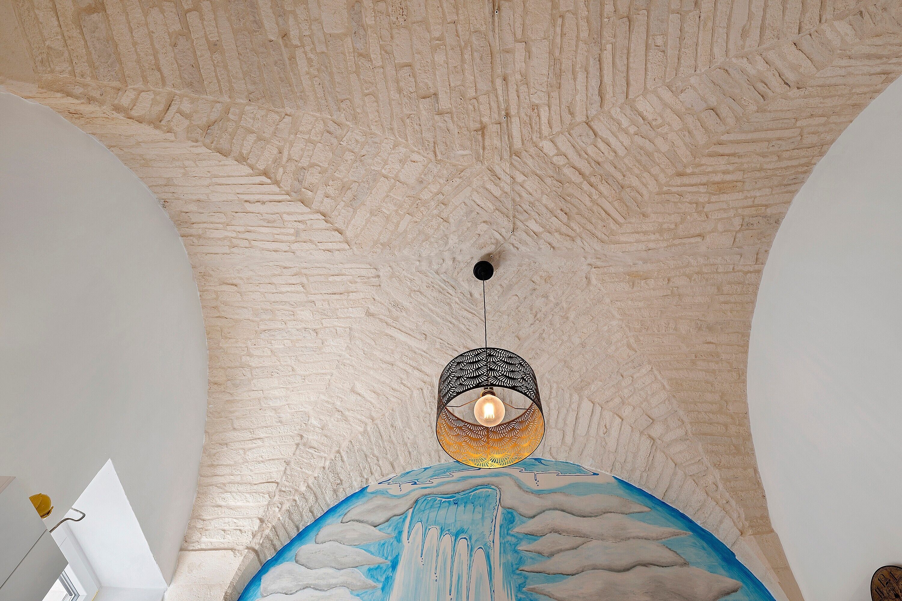 A room with a textured ceiling and a hanging light fixture.