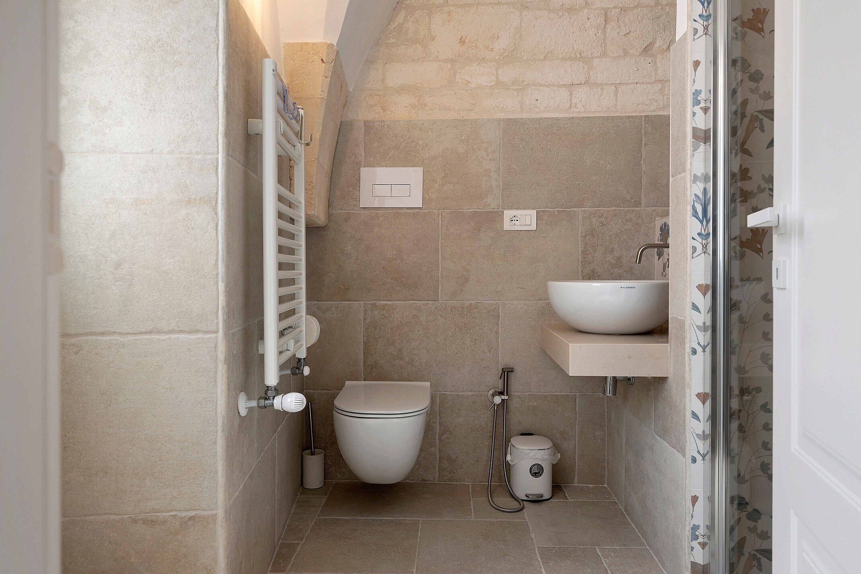 Ein kleines Badezimmer mit Toilette, Waschbecken und Dusche.