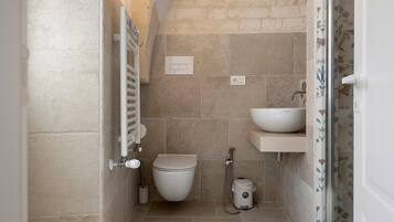 Ein kleines Badezimmer mit Toilette, Waschbecken und Dusche.