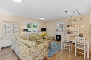 Ein Wohnzimmer mit einer Couch, einem Couchtisch und einem Essbereich mit Stühlen und einem Tisch.