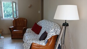 A room with a brown leather sofa, a white lamp, and a tripod on the floor. - Single-family home (Sarlat-la-Canéda)
