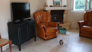 A living room with a fireplace, a television, and leather armchairs. - Single-family home (Sarlat-la-Canéda)