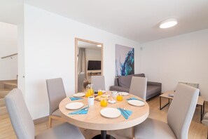 A modern dining area with a round table, chairs, and breakfast items. - Villa Omura 16 - Three Bedroom Villa, Sleeps 6 (Playa Blanca)