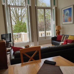 Ein Wohnzimmer mit einer Couch, einem Tisch und einem Fernseher.