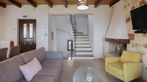 A hotel lobby with a staircase, sofas, a television, and a fireplace. - Villa Koule - Three Bedroom Villa, Sleeps 6 (Kalami)