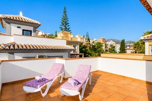 A rooftop terrace with two sun loungers, a tiled floor, and a view of surrounding buildings. - Villa Tropicana - Three Bedroom Villa, Sleeps 5 (Nerja)