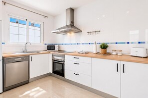 A modern kitchen with a dishwasher, microwave, stove, and a toaster. - Villa Tropicana - Three Bedroom Villa, Sleeps 5 (Nerja)