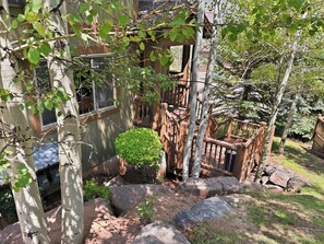 A residential area with a wooden fence, a small bush, and large rocks. - Family Neighborhood Nestled In Nature (Park City)