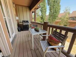 A covered outdoor patio with a grill, a table, and a bench. - Family Neighborhood Nestled In Nature (Park City)