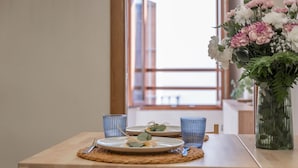 A dining table with plates, cutlery, and blue glassware, set with a woven placemat. - Cozy and lovely apartment located in the historic center of Málaga. (Málaga)