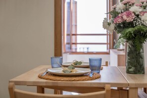 A dining table with plates, cutlery, and blue glassware, set with a woven placemat. - Cozy and lovely apartment located in the historic center of Málaga. (Málaga)