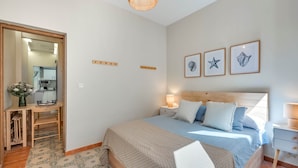 A bedroom with a bed, bedside table, lamp, and wall art. - Cozy and lovely apartment located in the historic center of Málaga. (Málaga)