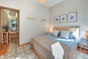 A bedroom with a bed, bedside table, lamp, and wall art. - Cozy and lovely apartment located in the historic center of Málaga. (Málaga)