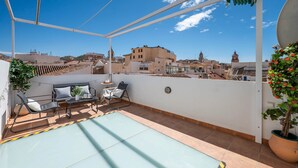 A rooftop terrace with a pool, seating area, and a view of the cityscape. - Cozy and lovely apartment located in the historic center of Málaga. (Centro Histórico)