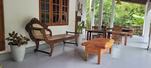 A wooden bench and table set in a room with a view of greenery outside.